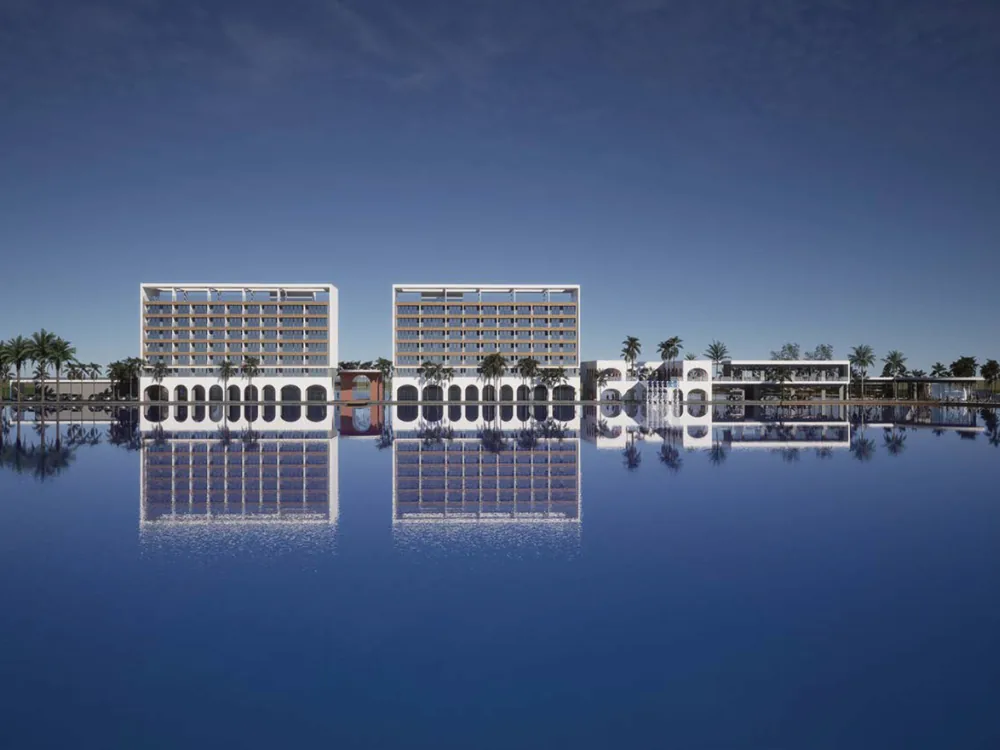 Twin lakefront hotel buildings with a mirror reflection on the water