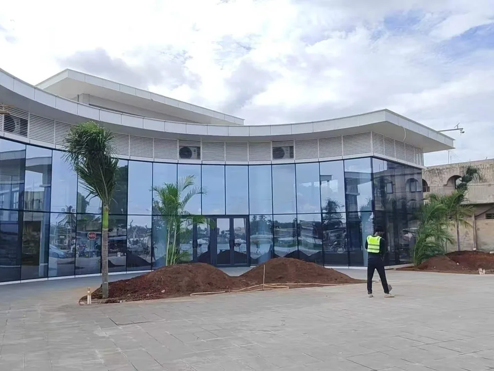 Curved glazed facade with planted forecourt