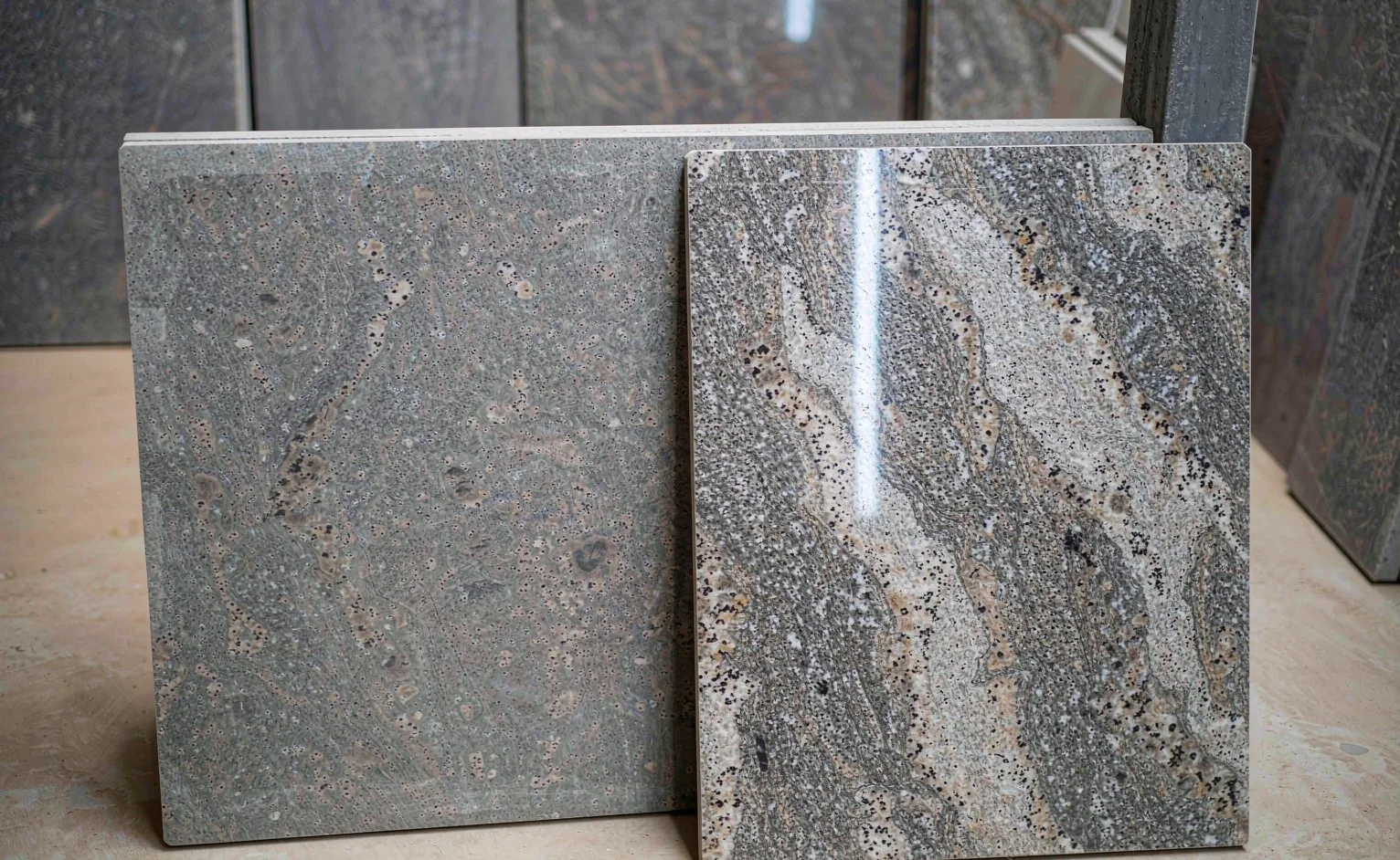 Honed and polished granite slabs compared in a stone showroom