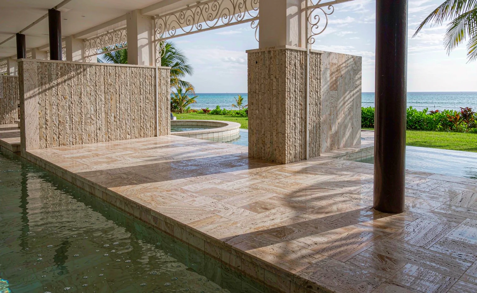 Brushed travertine pool deck at a coastal resort