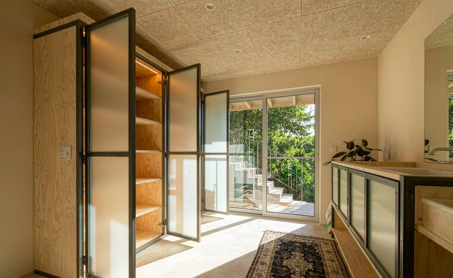 Marine plywood wardrobe carcase with aluminium frames in a tropical bedroom