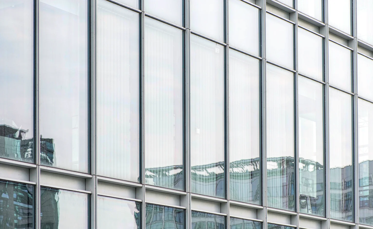 Unitised glass curtain wall with low-e glazing and aluminium mullions on a high-rise tower