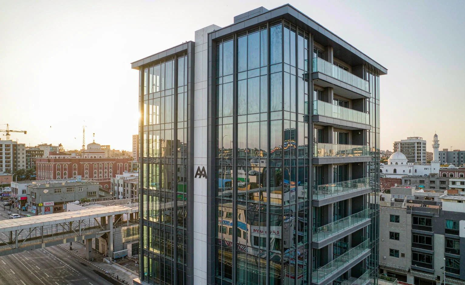 Glass-clad high-rise tower in an East African city at sunset - high-rise materials for G+10 projects