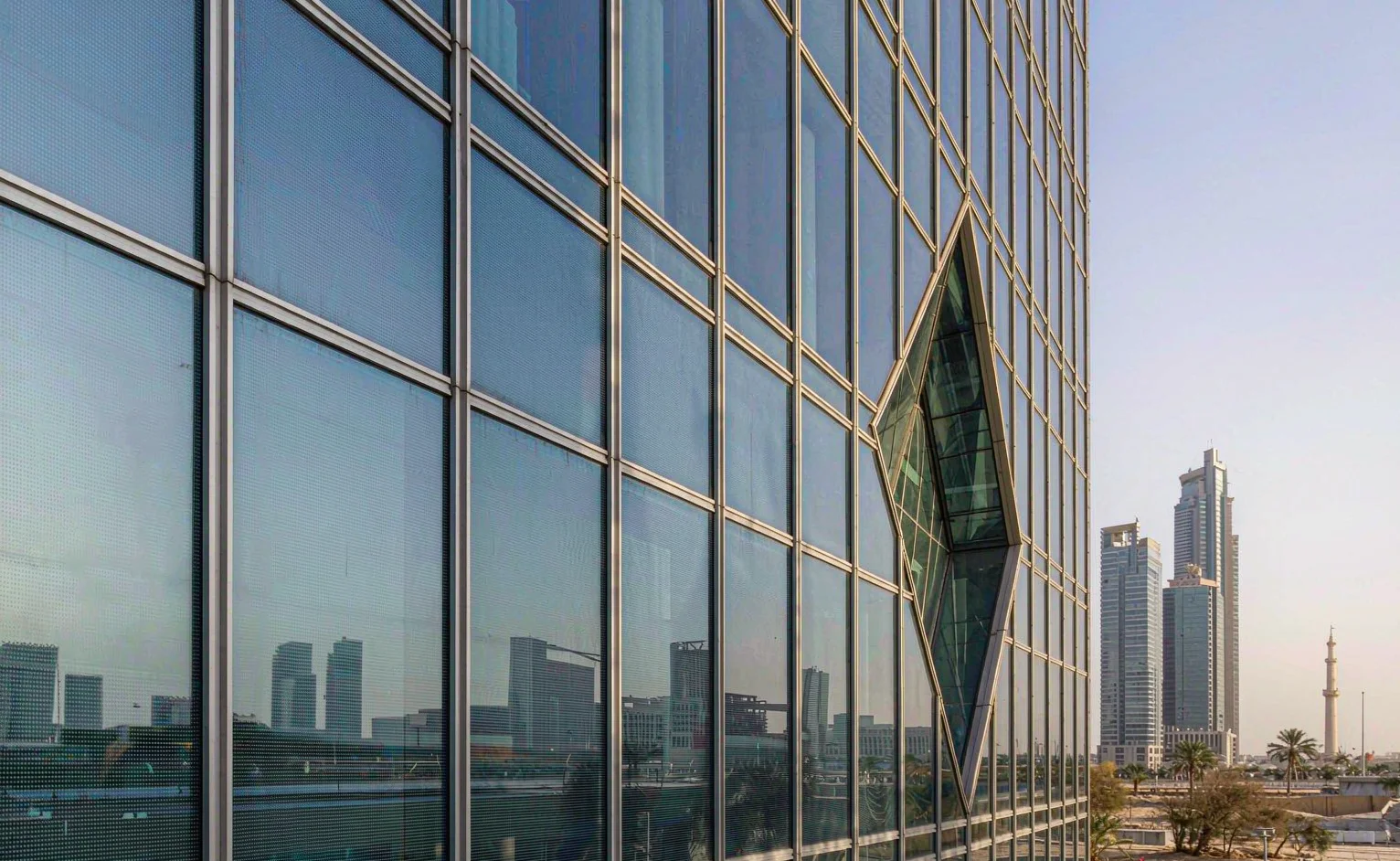 Glass curtain wall facade treated with heat-insulating solar reflective coating on a modern building in a Gulf city