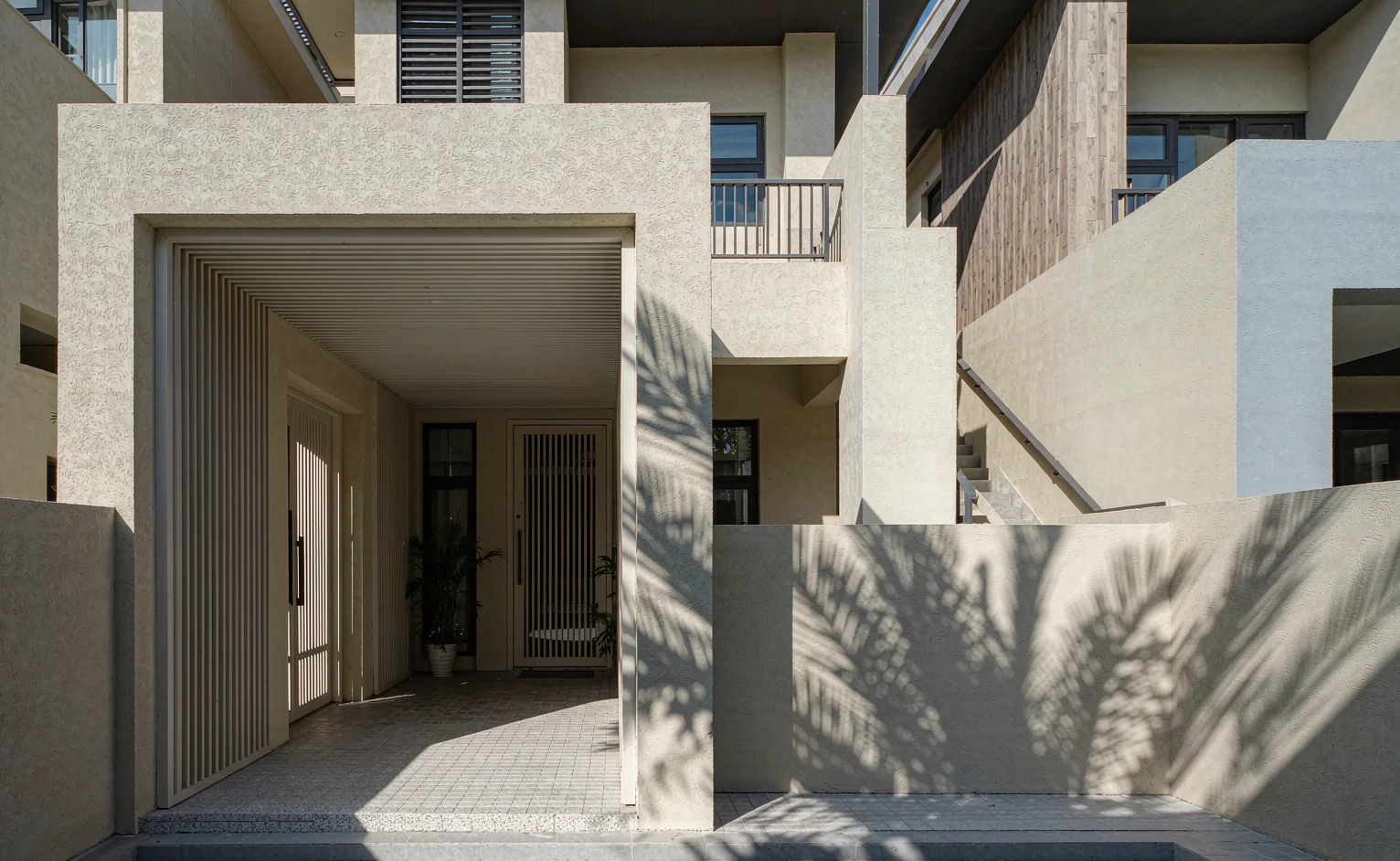 Modern villa exterior walls finished with textured stone-look paint under strong tropical sunlight in East Africa