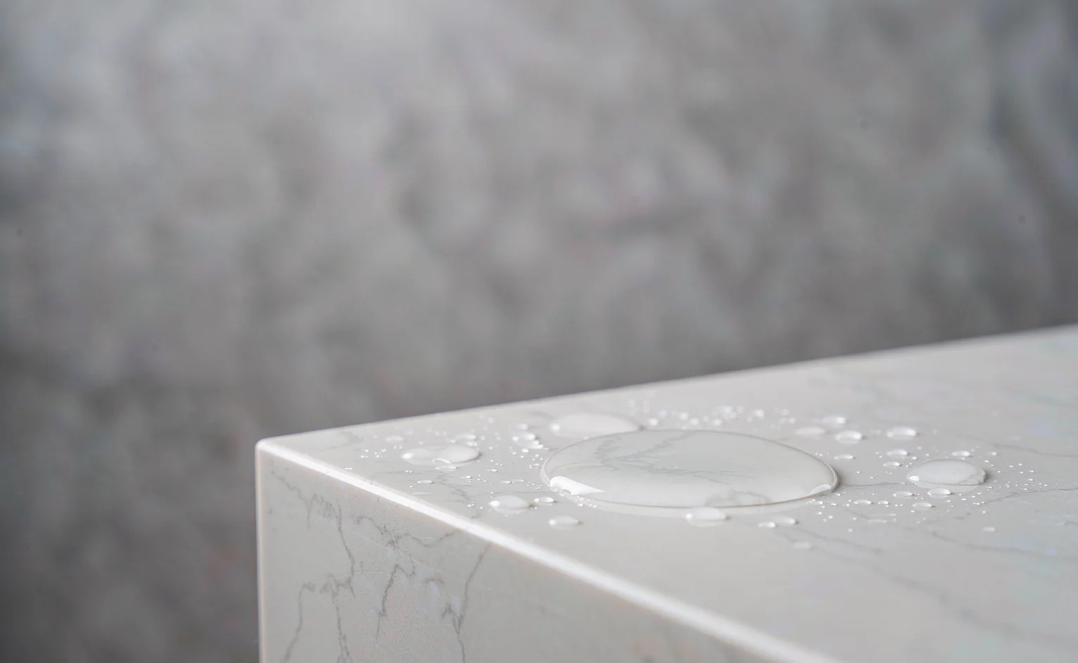Water beading on a sintered stone worktop corner, showing 0.1 percent absorption and stain resistance