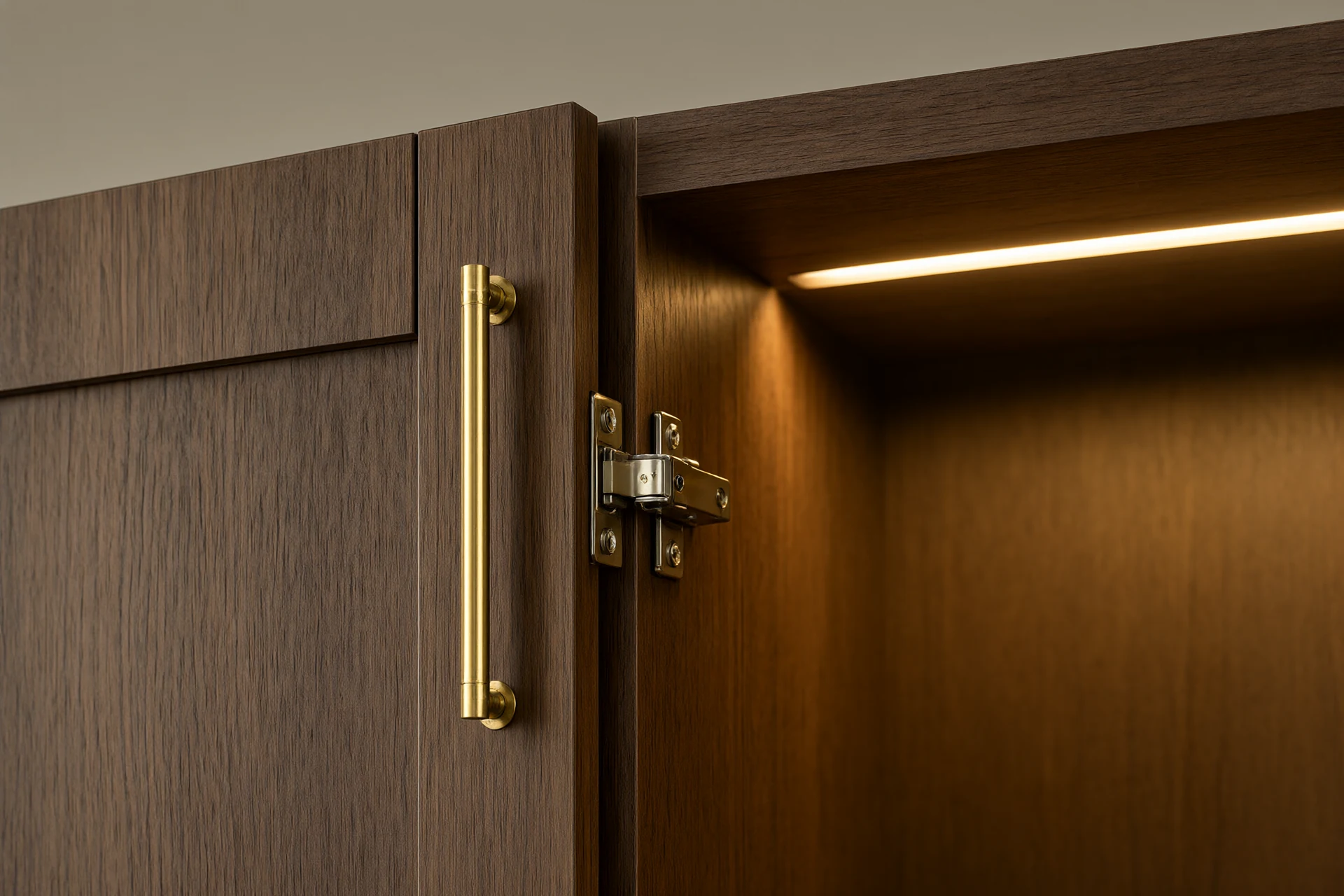 Walnut veneer wardrobe joinery detail with brushed brass pull, soft close hinge and hidden 2700 K LED strip inside