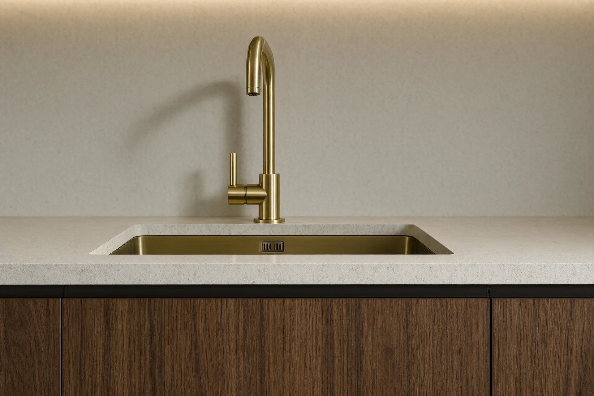 Macro kitchen material detail of a 20 millimetre sintered stone worktop with a brushed brass mixer tap and undermount sink beside a walnut cabinet front